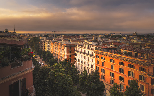 Dramatic early morning view of a street and tall buildings in Rome, Italy.