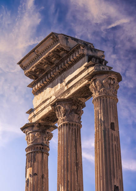 Remains of carved stone pillars at The Colosseum in Rome against a blue sky