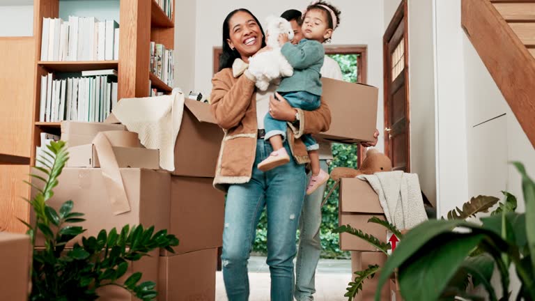 Moving, happy and new house with family at front door for future, investment and real estate. Cardboard boxes, sale and smile with parents and children in home for mortgage, property and growth