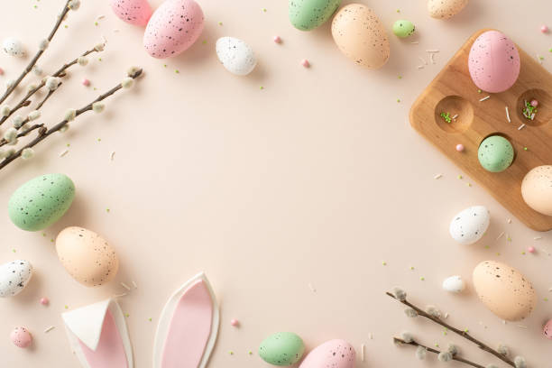istock Radiate Easter joy with this delightful composition. Top view of wooden holder for eggs, playful bunny ears, pussy-willow twigs and sprinkles on soft backdrop, creating perfect space for text or ad 2028992826