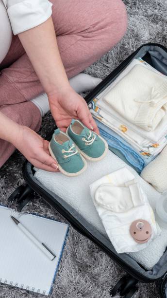 istock Pregnant woman's top view, floor-based preparations, packing with precision her maternity essentials, encapsulating the future mother's emotions 2028996133