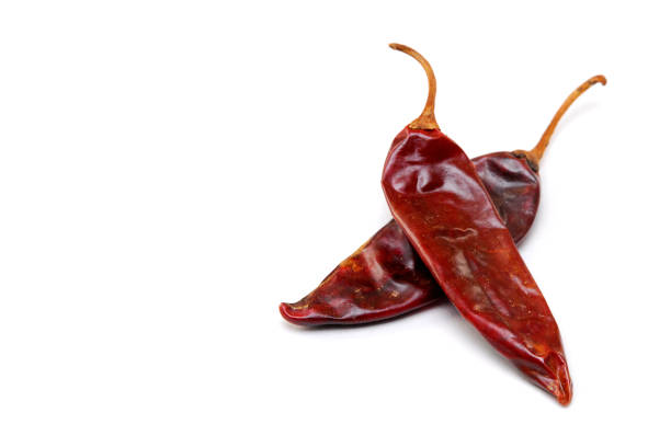 Dried red chili peppers on blue background representing spicy flavor, natural seasoning, and healthy lifestyle concept for cooking, nutrition, and traditional culinary design.