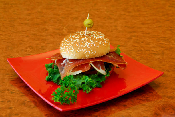 Beef burger with serrano ham on a wooden table