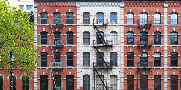 Block of historic apartment buildings with windows and fire escapes in the Tribeca neighborhood of Manhattan in New York City