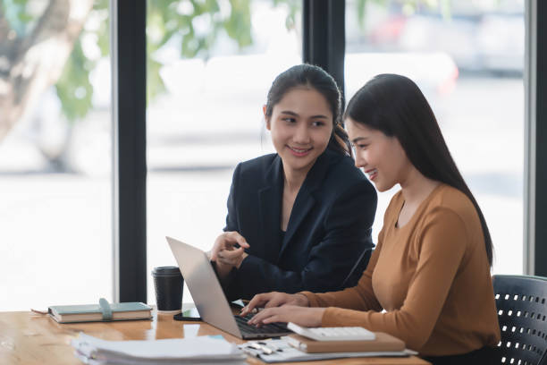 istock Motivated young female office workers discussing business plan, using laptop in the office room. 2029122679
