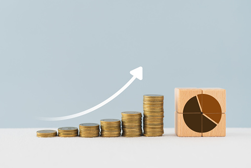 Increase market share, growth of business profit. Market penetration and expansion strategies. Wooden cubes with pie chart or market share percentage and stack of coins with increasing graph