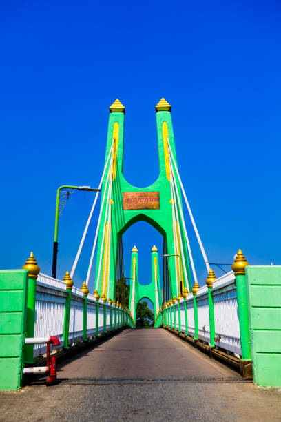 Green suspension bridge across Nan River at Chum Saeng District, Nakhon Sawan Province.