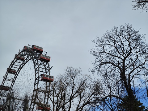 New York City, USA - November 23, 2018: On a clear and cold late November afternoon, a roller coaster stands idle nearby the boardwalk at the Atlantic Ocean beach. Coney Island amusement district, Brooklyn, New York City.