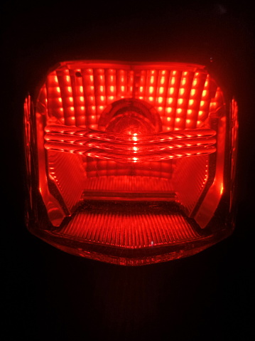 The red rear light of the motorbike is on