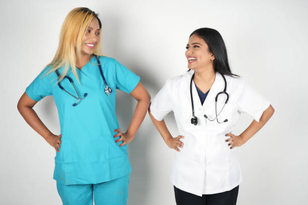 istock two nurse women talking to each other next to a white wall 2029404084