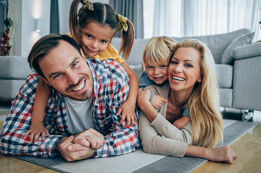 Shot of a cheerful young family relaxing together on the floor at home