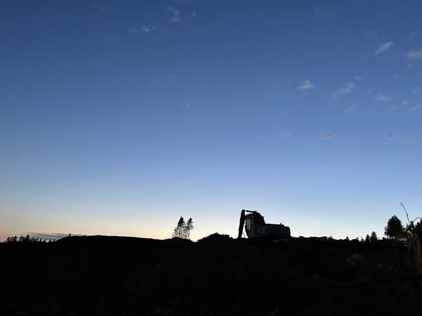 istock a silhouetted person is standing in the sunset behind a machine 2029443138
