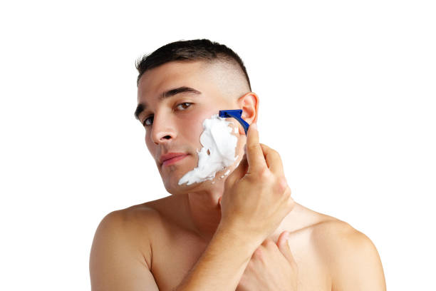 istock Young handsome man applying shaving foam against white background 2029456690
