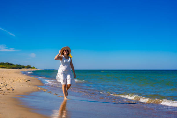 istock Beautiful woman walking on beach 2029458790
