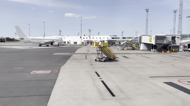 A white plane and warehouses and hangers at an international airport