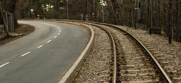 Train track next to the road at the old Camorritos station in Cercedilla, community of Madrid, Spain. Public transportation concept