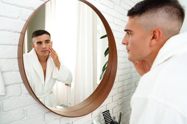 istock Young man looking in the mirror in the bathroom 2029488537