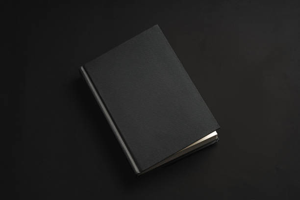 istock Black hardcover book or notepad mock up on black background 2029507026