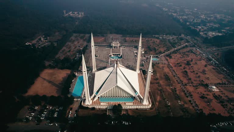 Faisal Mosque in Islamabad with surrounding landscape in daylight, aerial shot