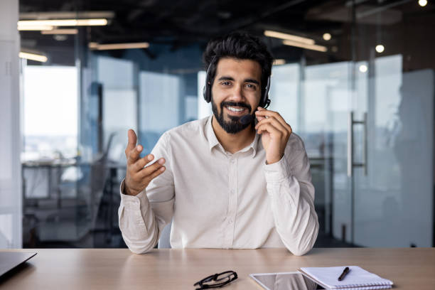 istock Confident young indian businessman using headset and gesturing in office 2029607154
