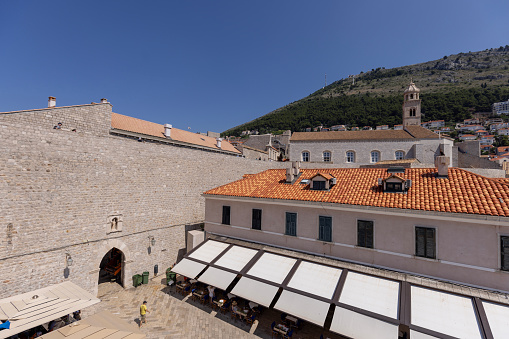Dubrovnik, Croatia - June 27, 2023: View of City Walls surrounding medieval city on the Adriatic Sea, entrance gate from the Old City to the port
