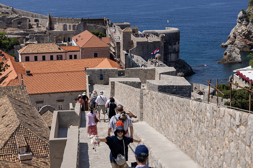 Dubrovnik, Croatia - June 27, 2023: Tourist walking route around the City Walls surrounding the medieval city by Adriatic Sea