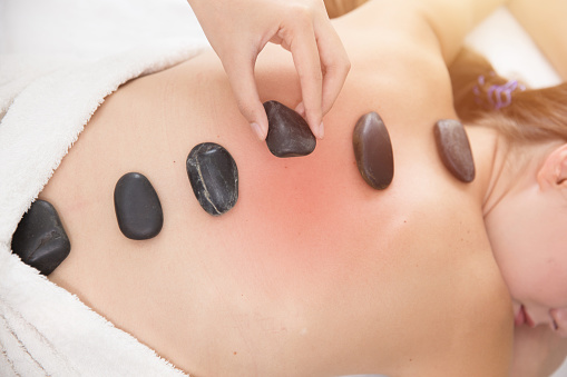 Hot Stone Massage muscle pain relief alternative therapy procedure in spa body healthcare