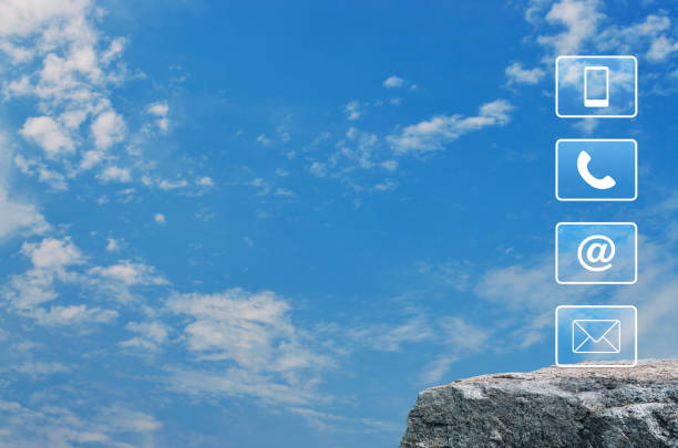 Telephone, mobile phone, address and email icon on rock mountain over blue sky with white clouds, Business customer service and support online concept