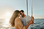 Cheerful couple couple in love talking on boat at sea.