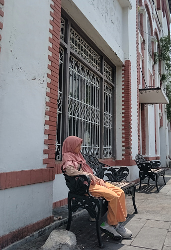 Asian young girl is contemplating on the bench.