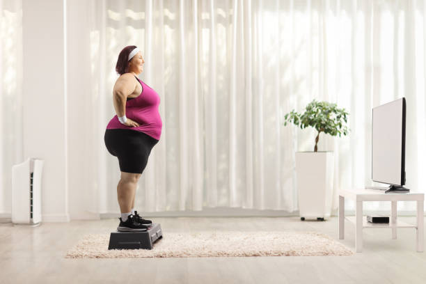 istock Woman standing on a stepper and watching aerobic class 2029672878