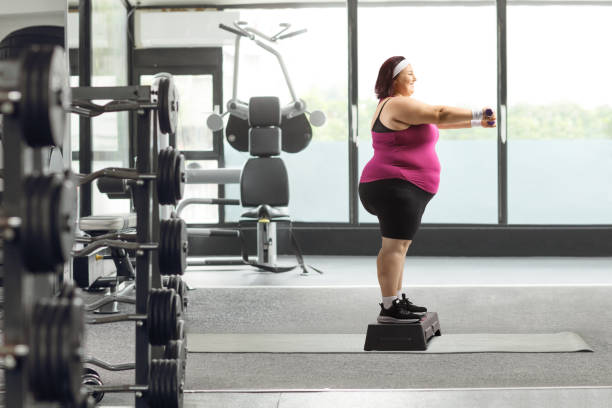 istock Woman standing on a stepper and exercising with dumbbells 2029672883