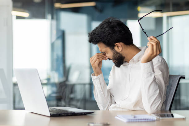 istock Exhausted indian businessman feeling stressed at work while sitting at his office desk 2029689099