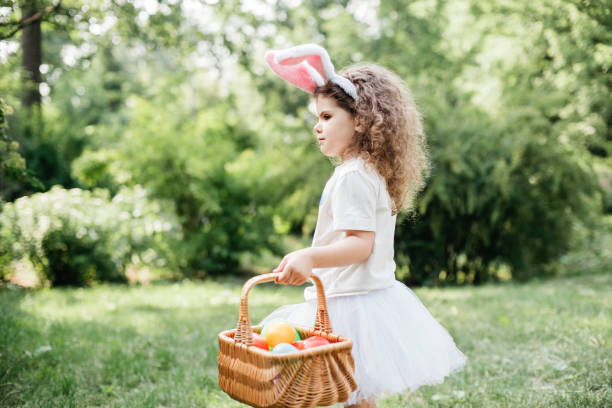 istock Baby with basket full of colorful eggs. Easter egg hunt. 2029704748