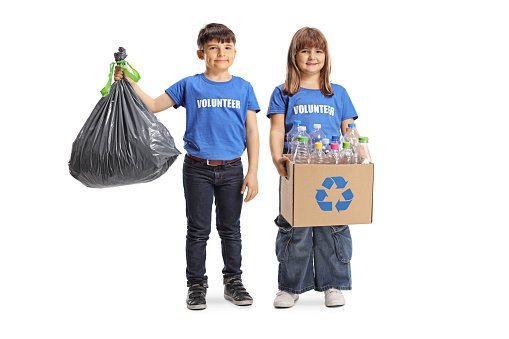 Children volunteers holding a waste bag and recycling box isolated on white background