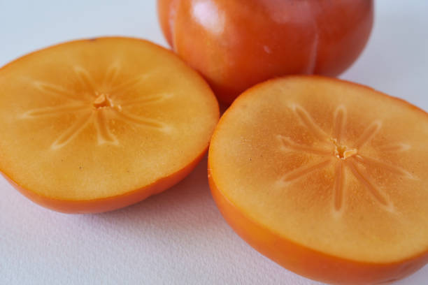 Three whole persimmon oranges kaki fruit on white background, organic food, studio shot