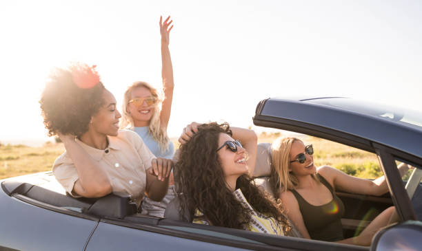istock Girlfriends having fun on road trip with car 2029721849