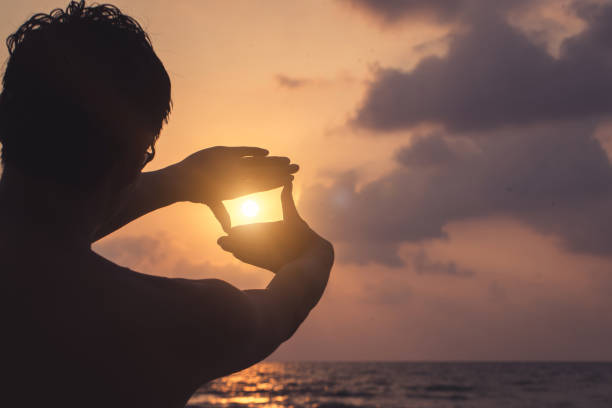 istock Silhouette Hand Framing Sun at Beach Sunset 2029724518