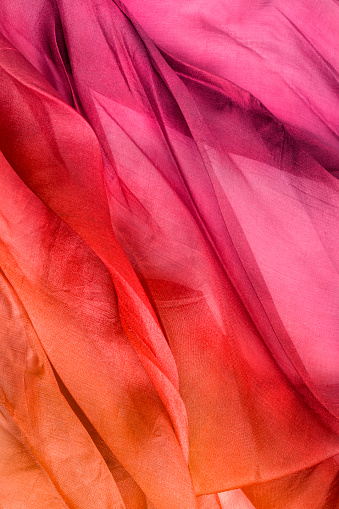 Pink and yellow ombre color draped tulle closeup as a background