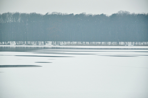 Winter landscape overlooking a lake in Poland, covered with snow, idyllic atmosphere