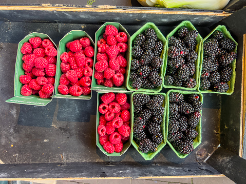 Delicious and fresh berry fruits is waiting for its customers in a box on the market counter. Suitable for background use and large writing space.