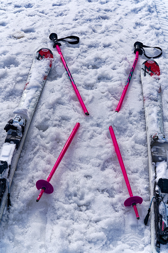 High angle close-up view of pair of skis and pair of broken alpine sky sticks in the Swiss Alps at ski resort of Engelberg Titlis. Photo taken February 21st, 2024, Titlis, Engelberg, Switzerland.