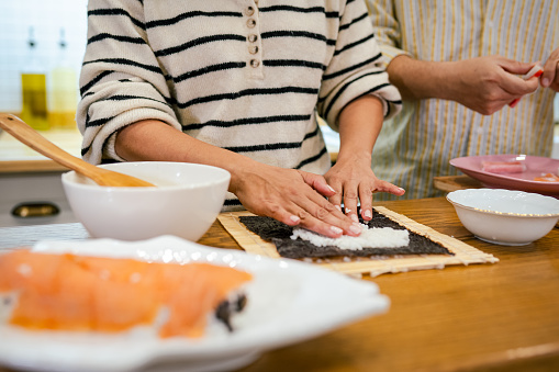 Young Couple making sushi together in the kitchen