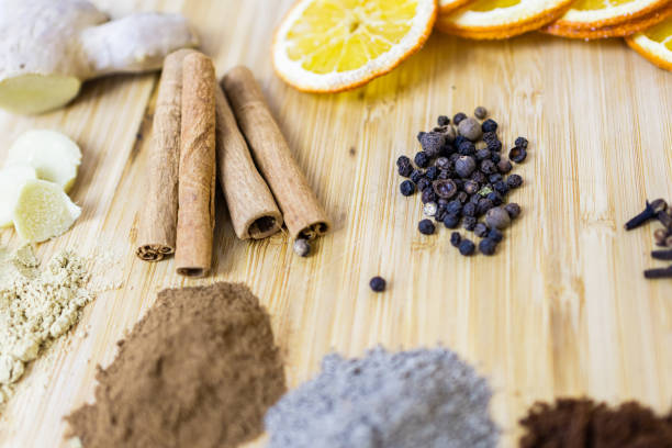 Dry ginger bread ingredients: cinnamon, ginger, black pepper, nutmeg, cloves and orange slices on wooden board. Spices for all tastes.