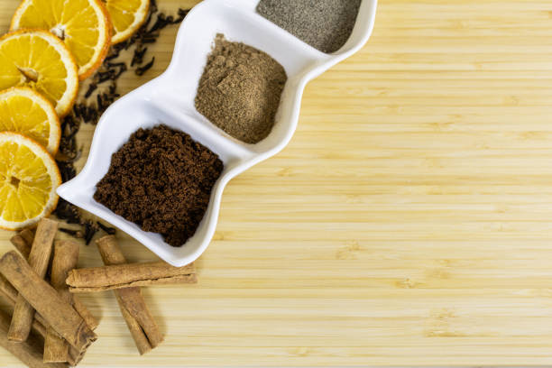 Dry ginger bread ingredients: cinnamon, ginger, black pepper, nutmeg, cloves and orange slices on wooden board. Spices for all tastes.
