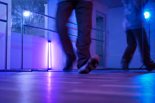 istock Low section of hip hop dancers legs dancing in studio with neon lights 2029862654