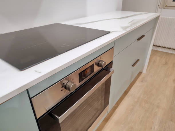 istock Marbled ceramic countertop, set on a blue-green kitchen cabinet with bronze handles. 2029871367