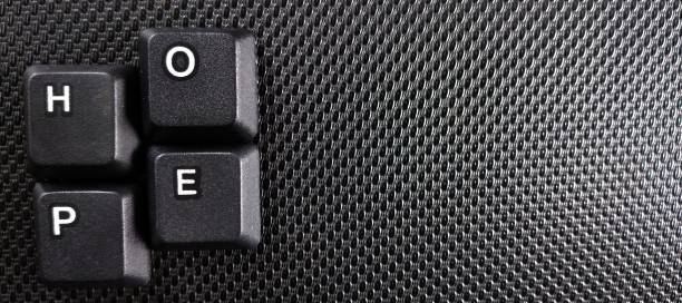 istock The word hope written with black computer keys on a black background. 2029871410