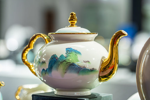 A cup of hot tea served in an ornate patterned cup and saucer - studio shot.