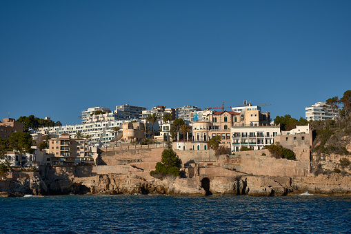 Buildings of the Cala Mayor above the sea on a blue day in Palma de Mallorca, Spain